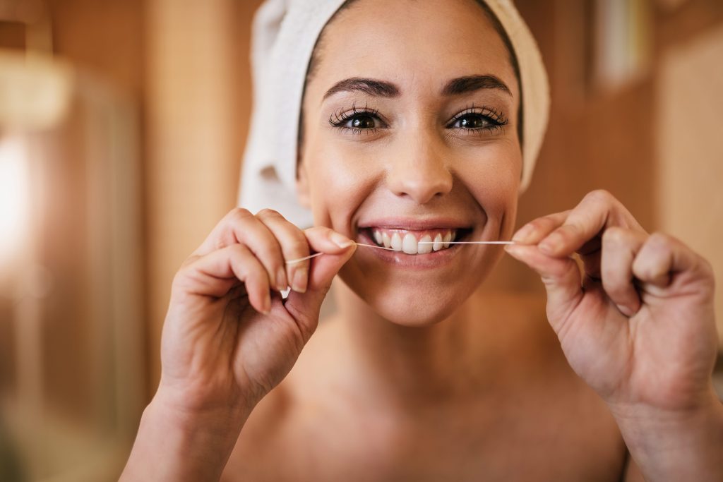 woman flossing her teeth